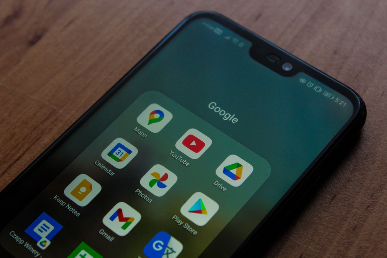 creative-approach-img Close-up of a smartphone showing various Google apps on its screen.